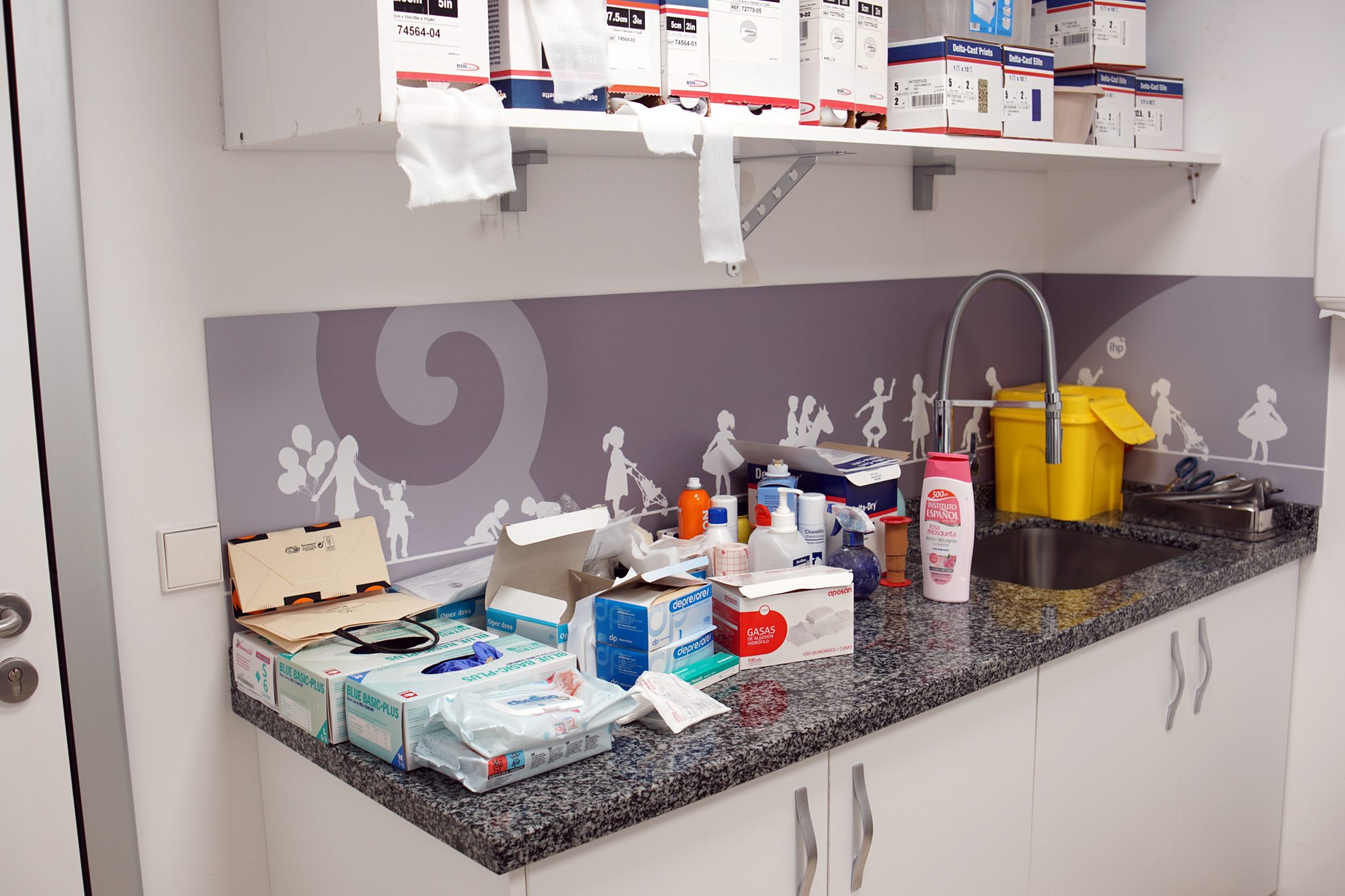 Medical supplies including gloves, gauze, bottles, and boxed dressings in a clinic